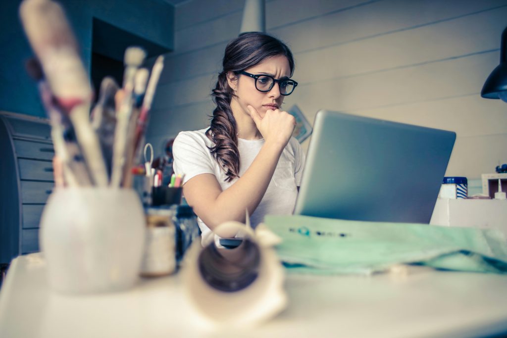 7 Rules for Rational Thinking: How To Hack Your Brain 1 a woman looking at a laptop and thinking